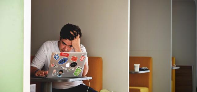 man wearing white top using MacBook by Tim Gouw courtesy of Unsplash.